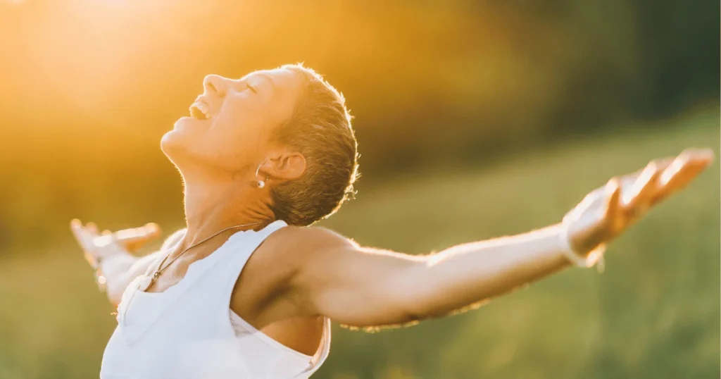 woman embracing sunlight in peaceful moment of self care and wellness